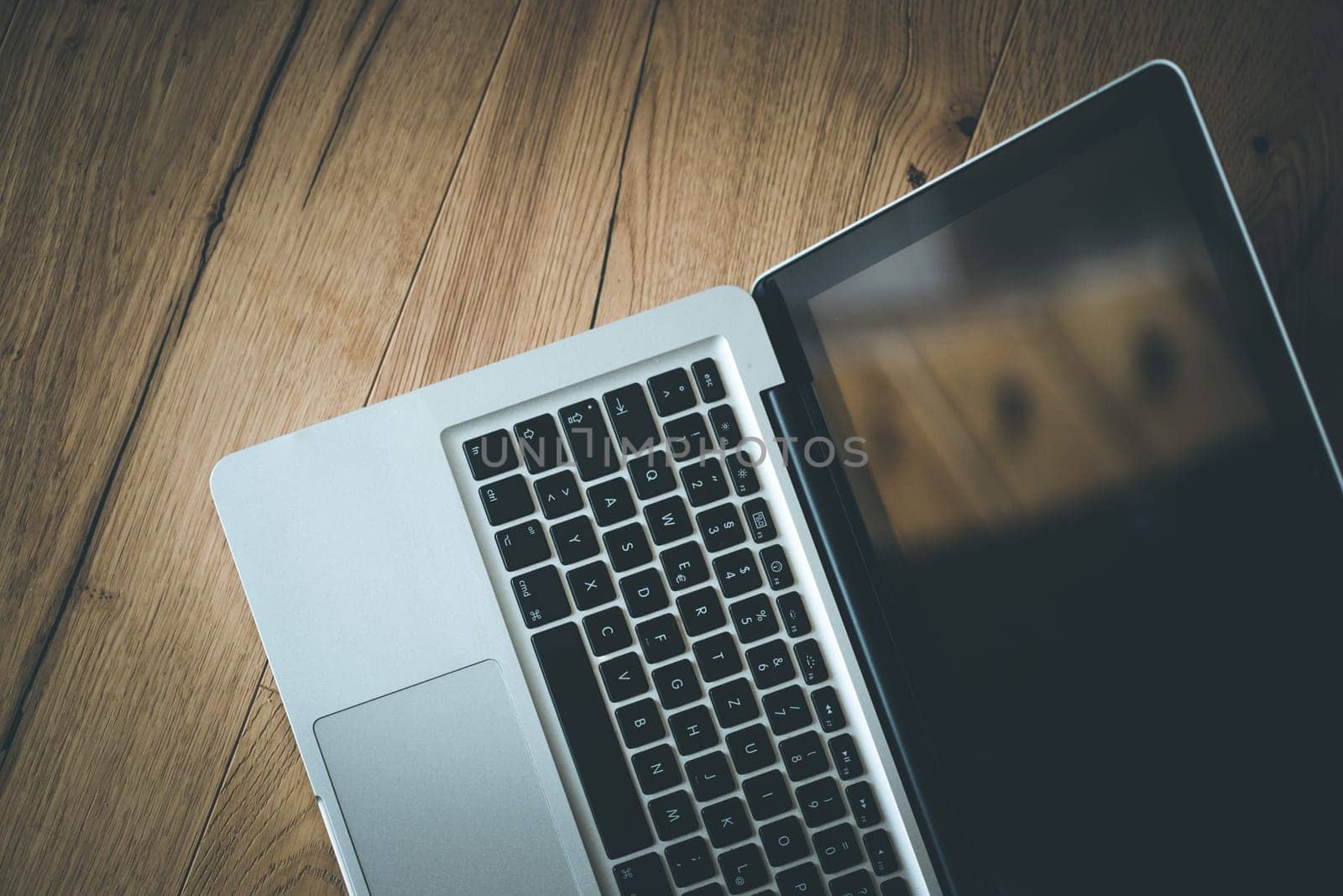 Close up of a laptop keyboard on a rustic wooden desk