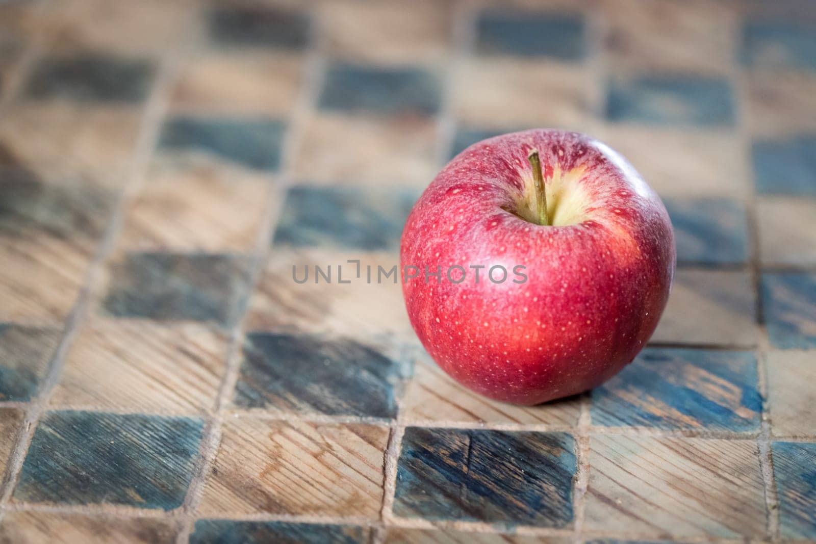 Close up of a red apple on a checked board