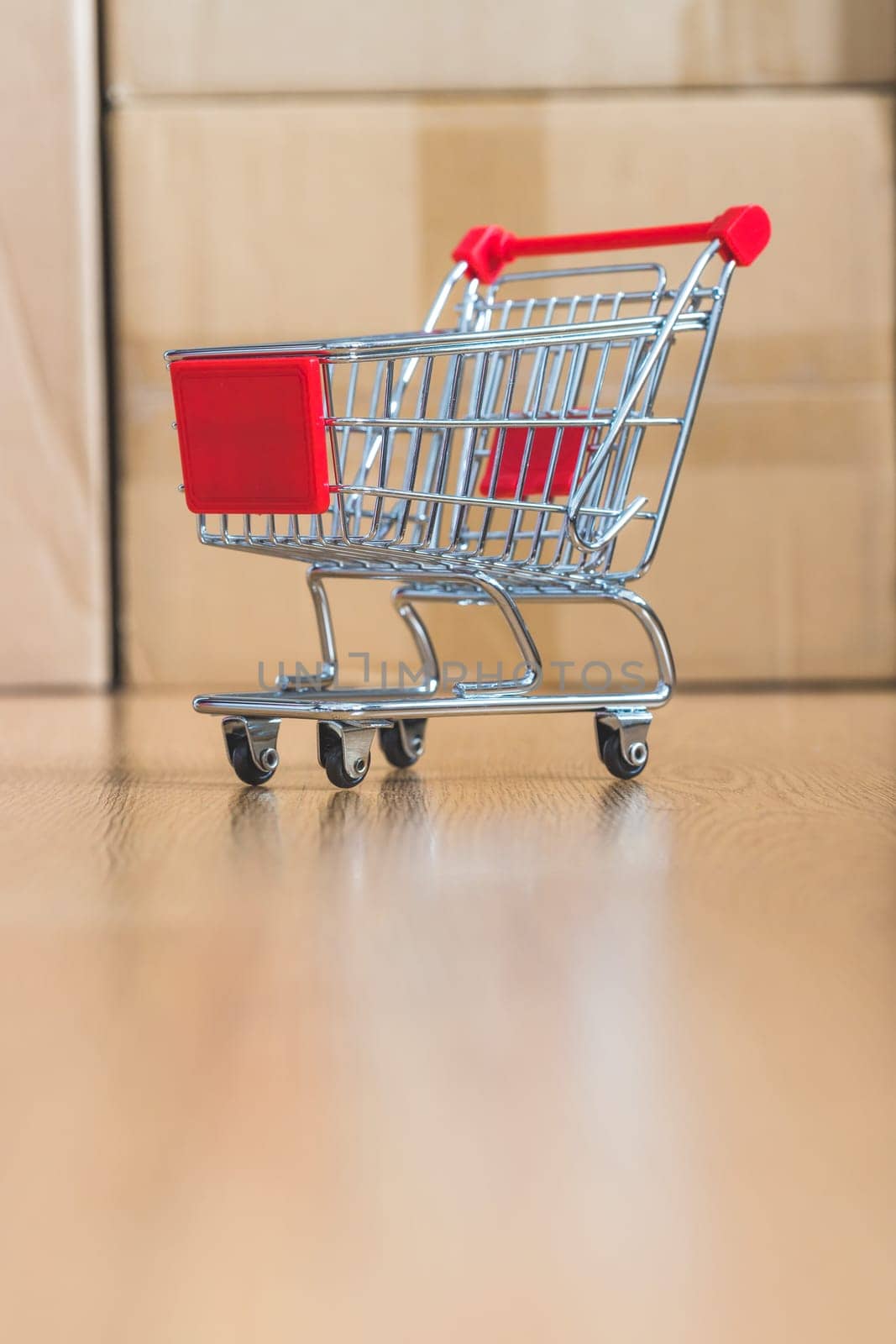 Online-Shopping and parcel service concept: Miniature shopping cart and cardboard boxes