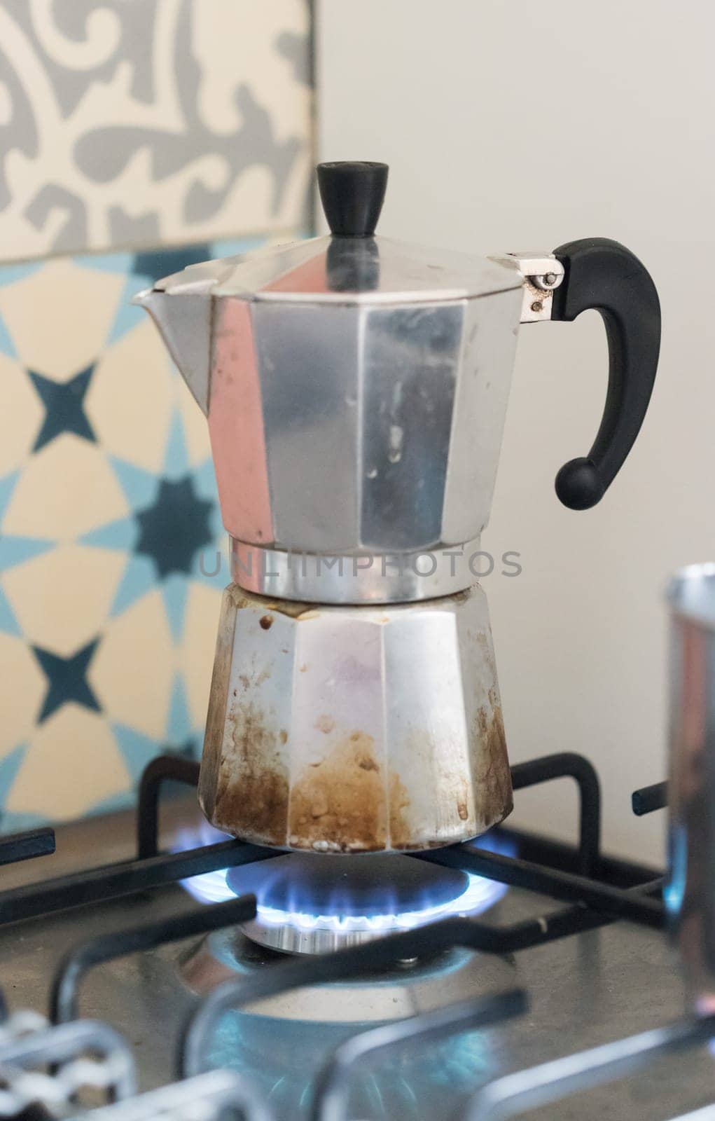 Close up of a blue gas flame, cooking a water pot in kitchen