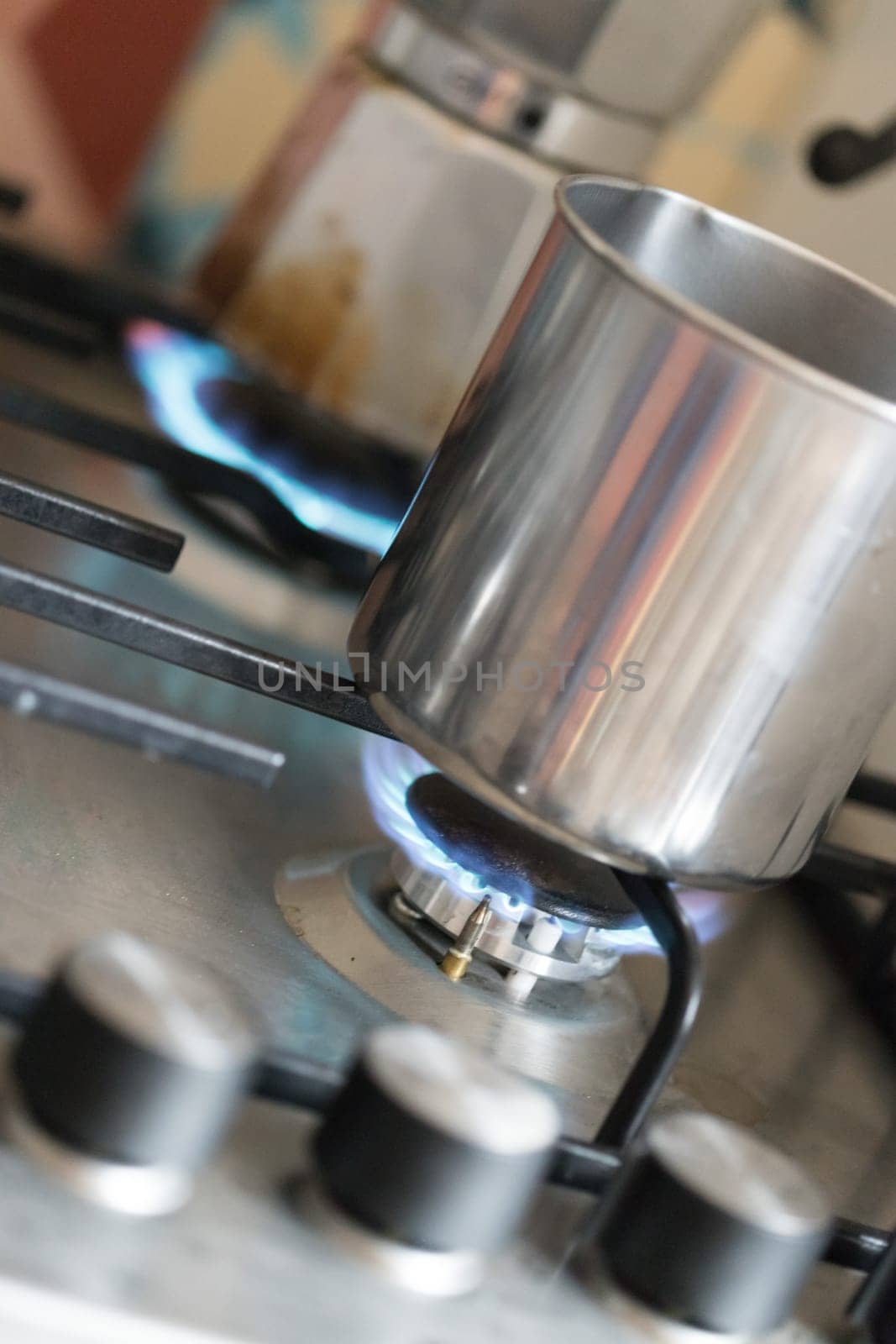 Close up of a blue gas flame, cooking a water pot in kitchen