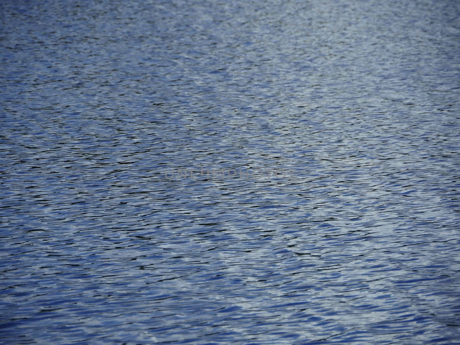 small ripples on the surface of the river abstract blue background