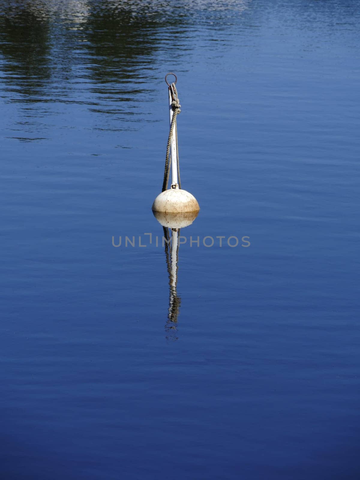 mooring buoy reflected in blue water in summer, yachting concept