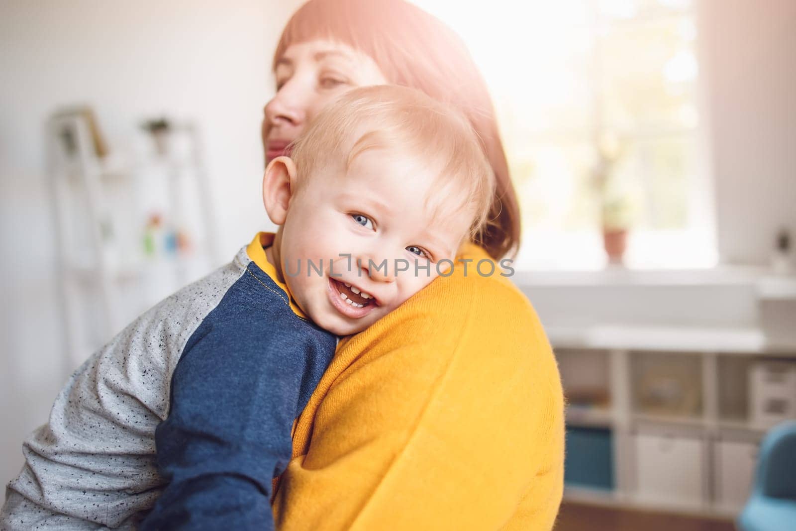 Happy mother embracing her smiling son carefully. Concept of the family relationship and mother's love.