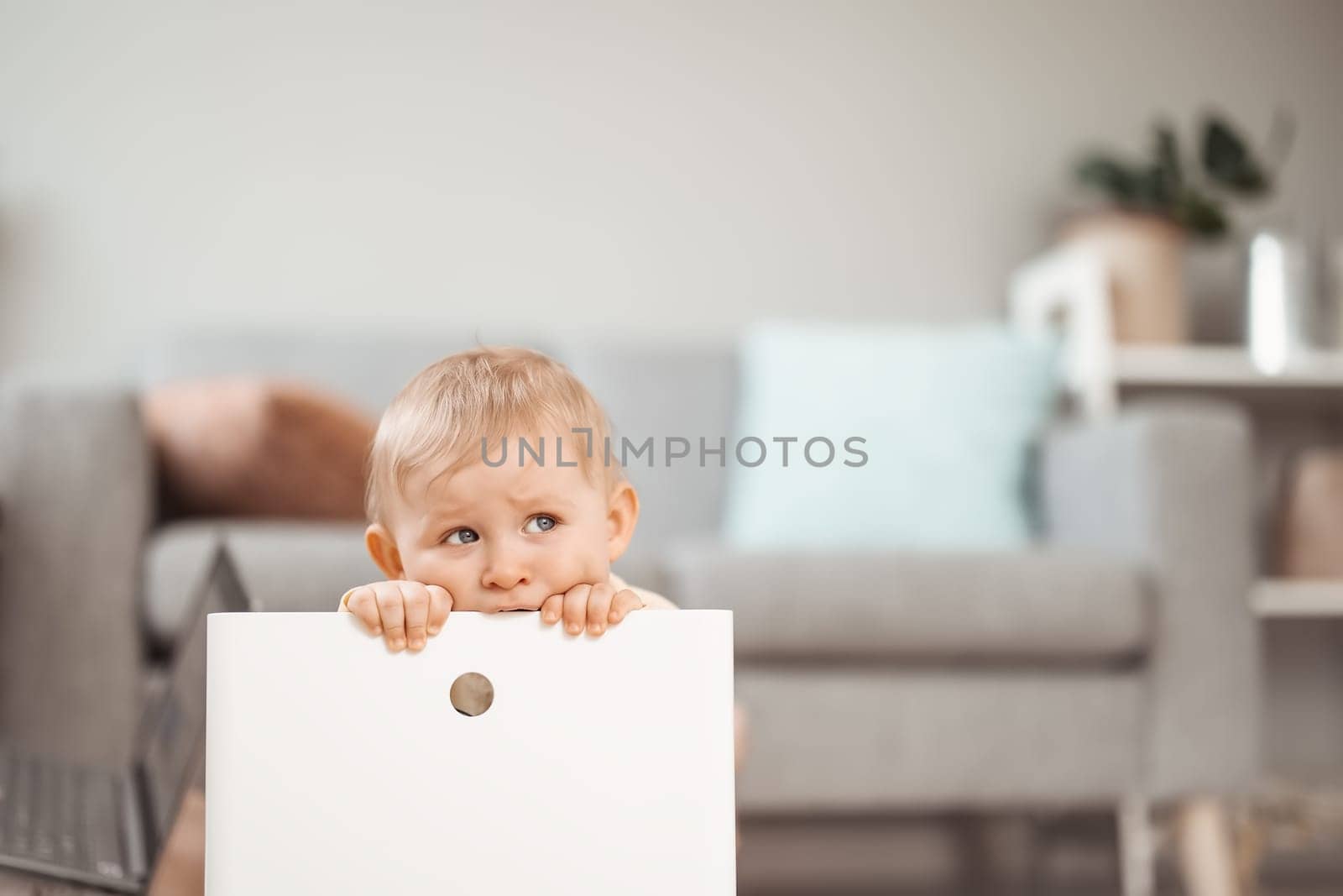 Cute boy sitting in the white plastic box. Tired child. Concept of the family and mother's love.