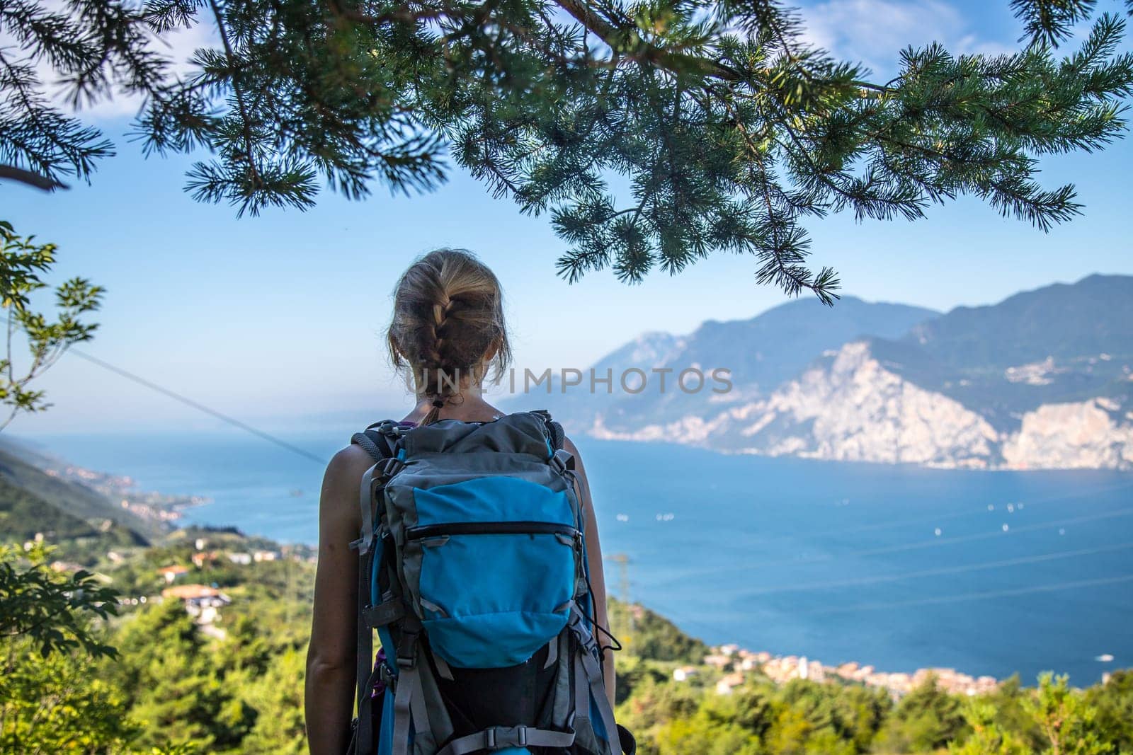 Young girl stands happily on Monte Baldo and enjoys the view. Hiking in Italy.