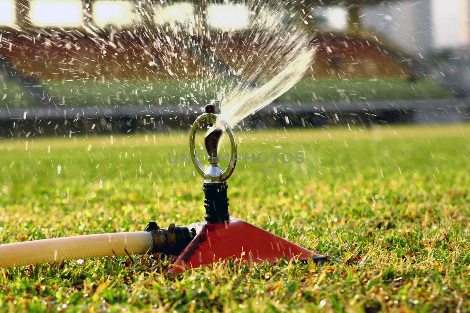 Water jets sprinkling stadium field.