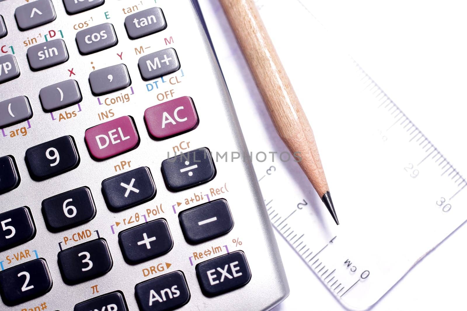 close-up of ruler,calculator,and pencil,focus on pencil-tip.