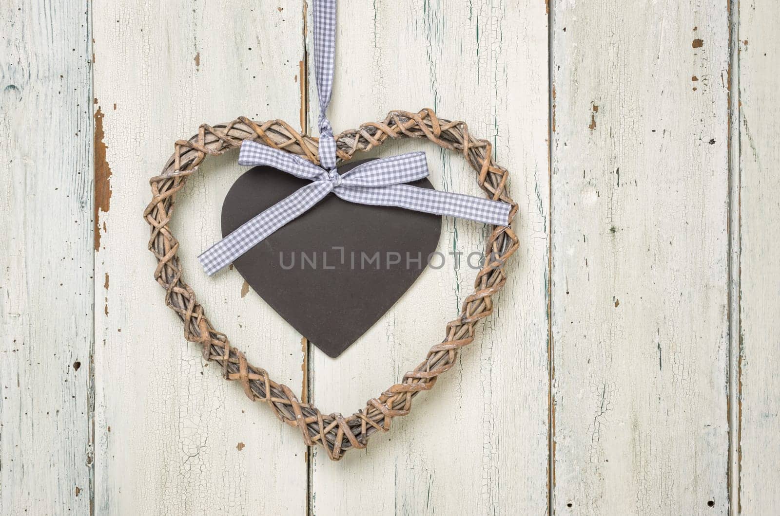 Heart with chalkboard in front of white wooden boards