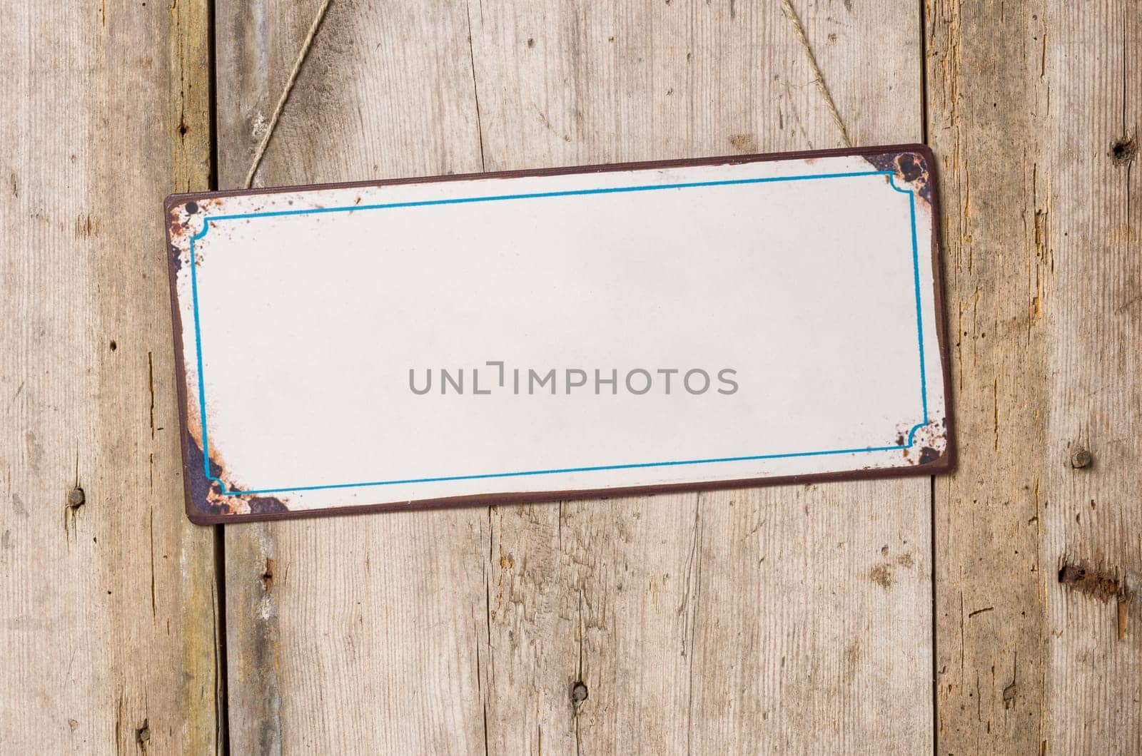 Empty tin sign in front of rustic wooden wall