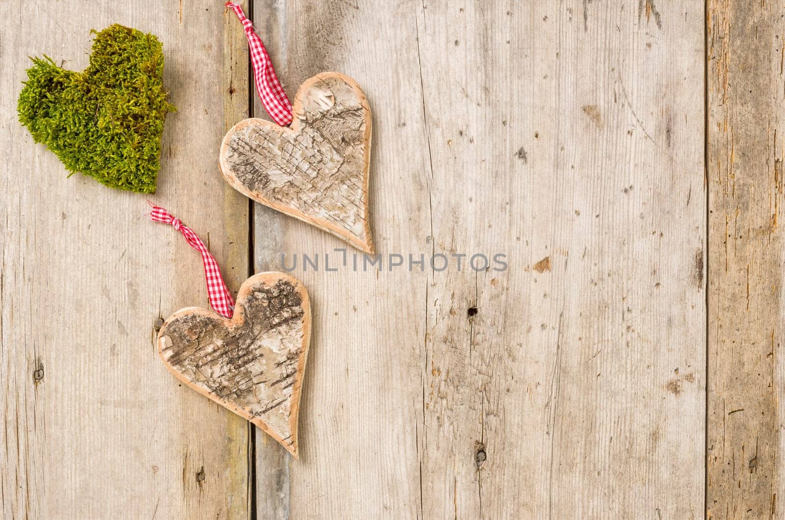 Hearts of bark and moss in front of rustic wooden boards