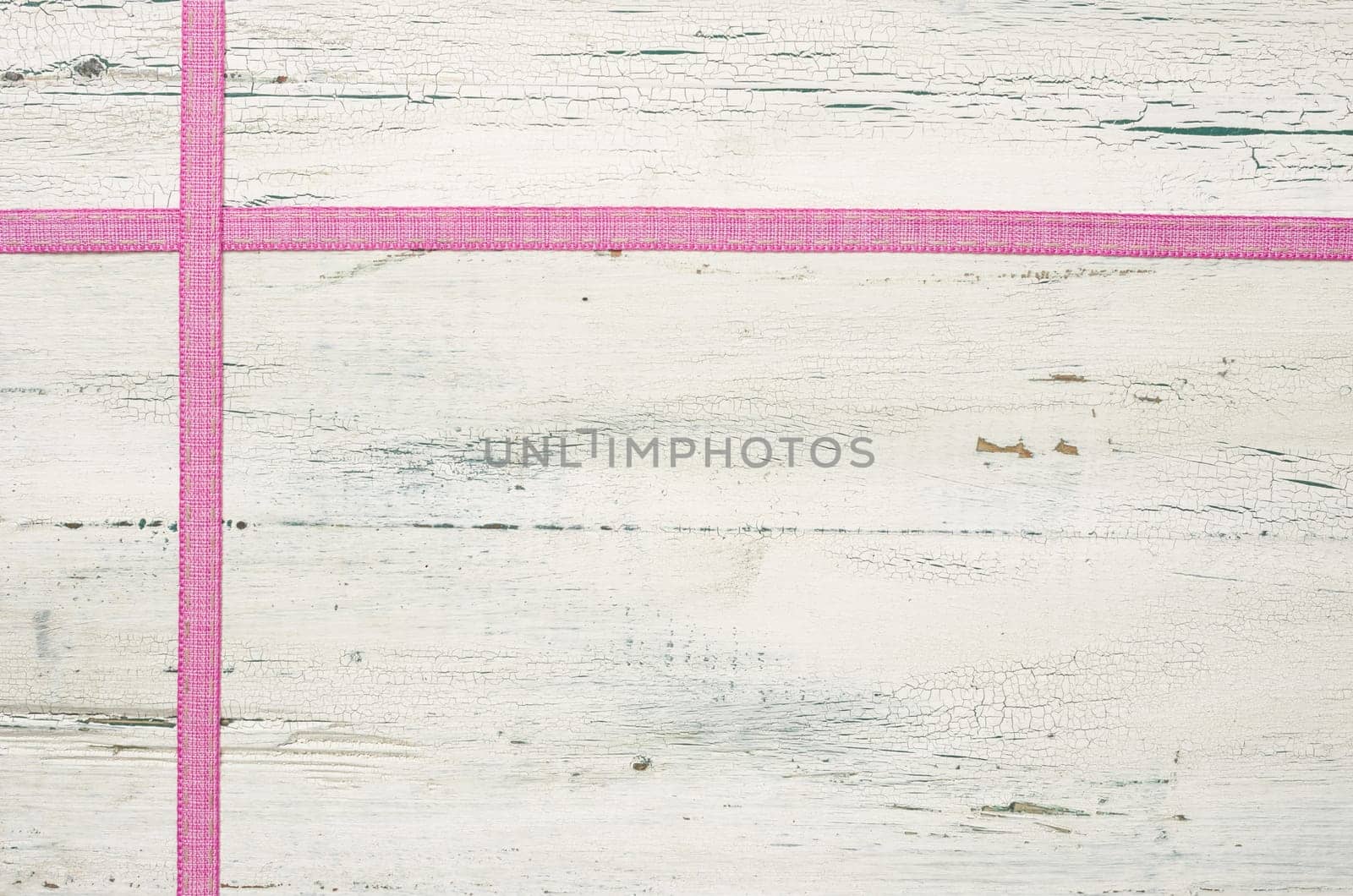 Pink gift ribbons in front of white wooden boards