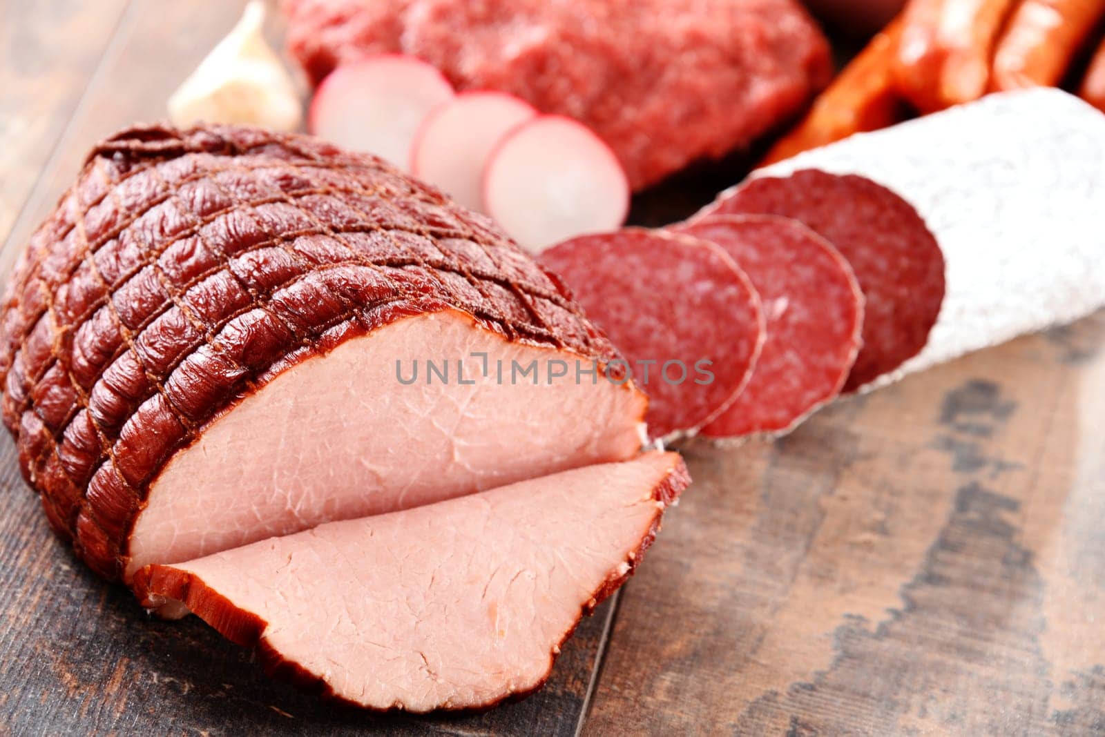 Assorted meat products including ham and sausages.
