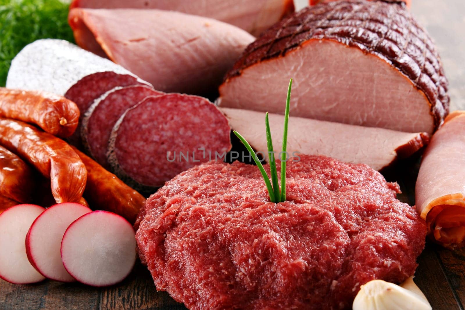 Assorted meat products including ham and sausages.