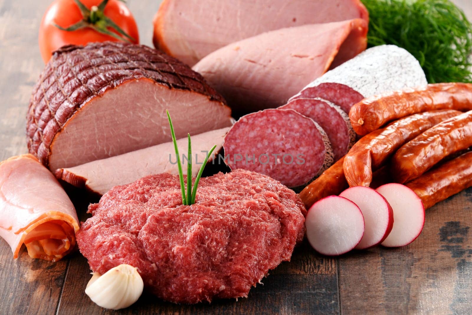 Assorted meat products including ham and sausages.