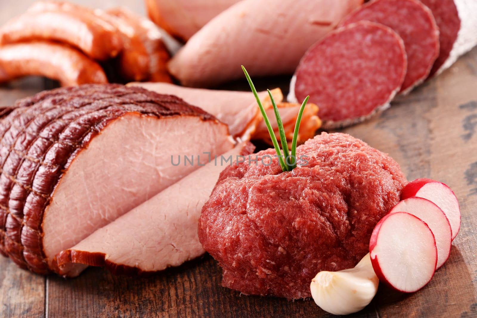 Assorted meat products including ham and sausages.