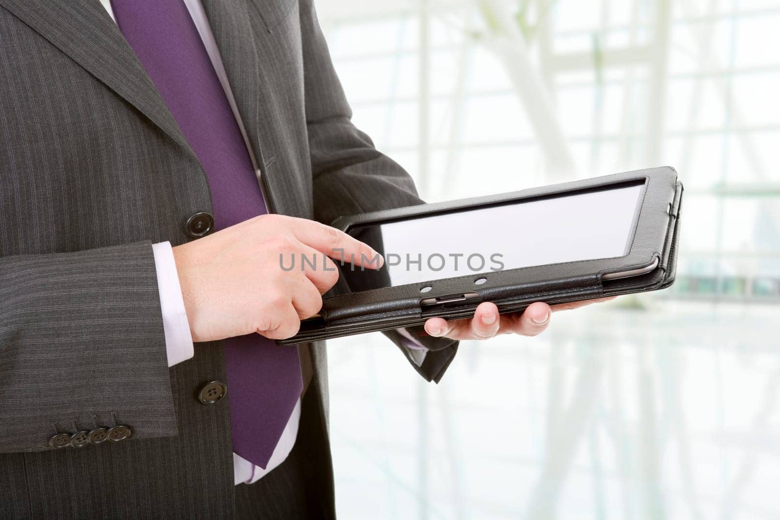 businessman using touch pad, close up shot on tablet pc, at the office