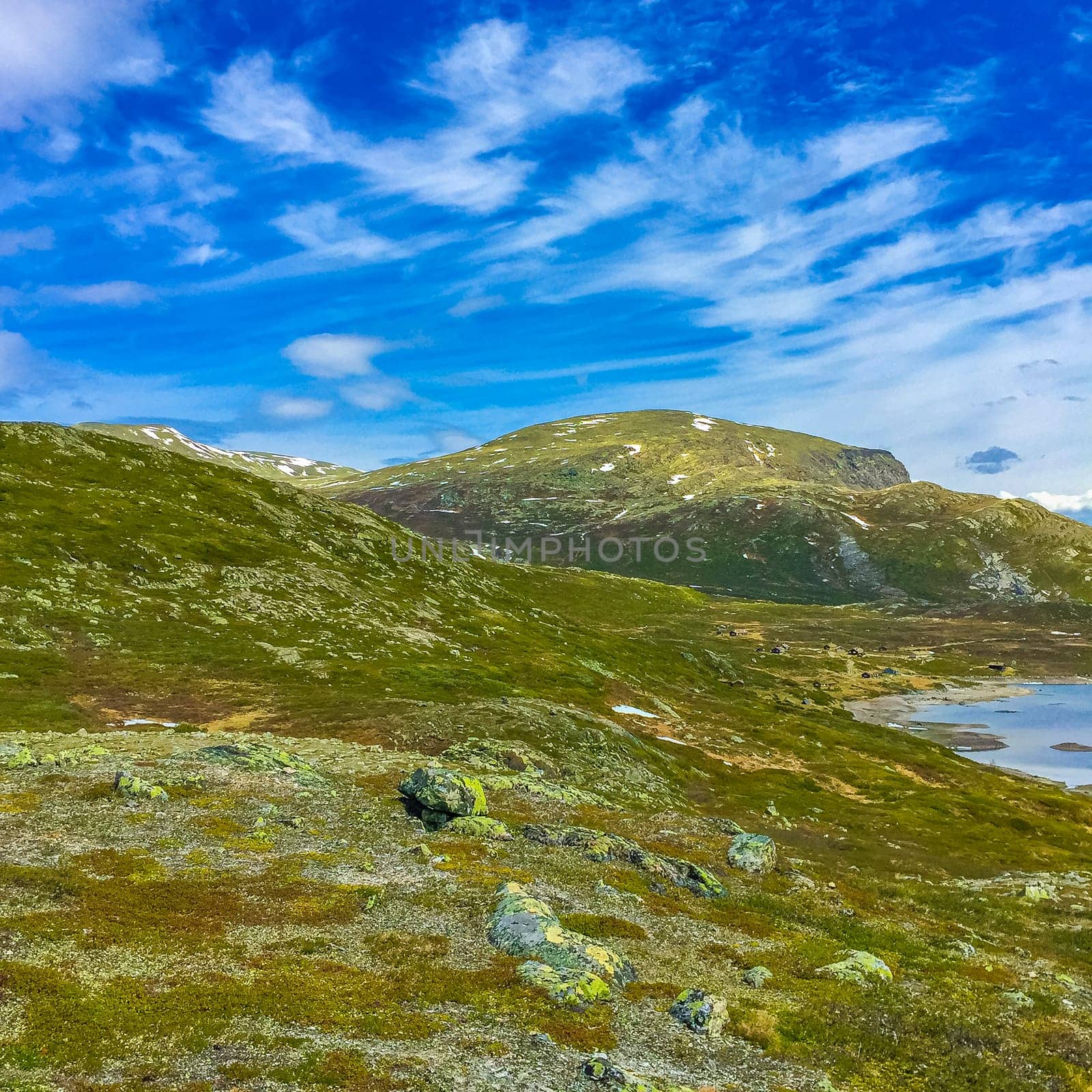 Amazing Vavatn lake panorama rough landscape view rocks boulders and mountains during summer in Hemsedal Norway.
