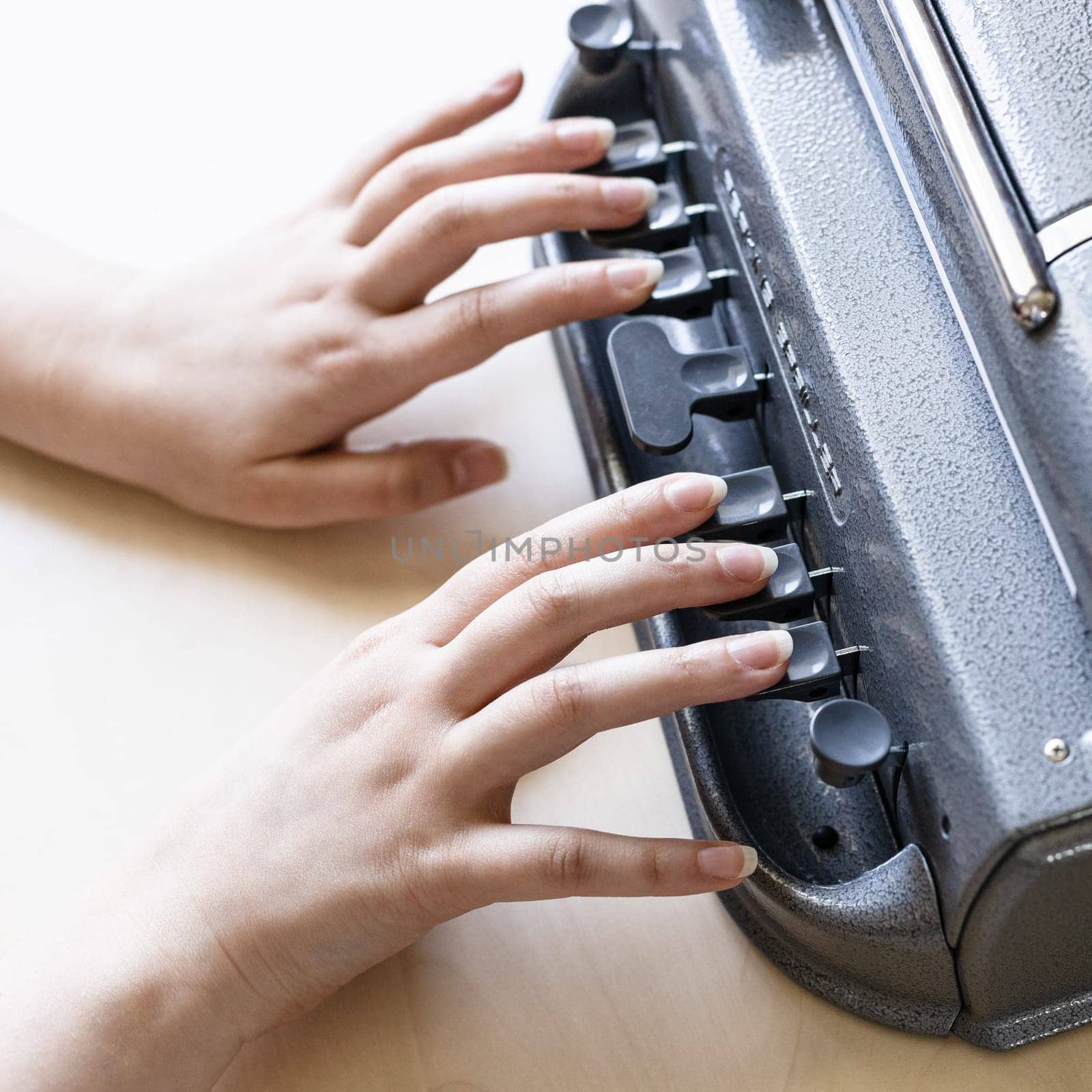 Moscow, Russia - June 5, 2021: fingers on keys of Perkins Brailler braille typewriter . The first Perkins Brailler was produced in 1951 by David Abraham, teacher at the Perkins School for the Blind