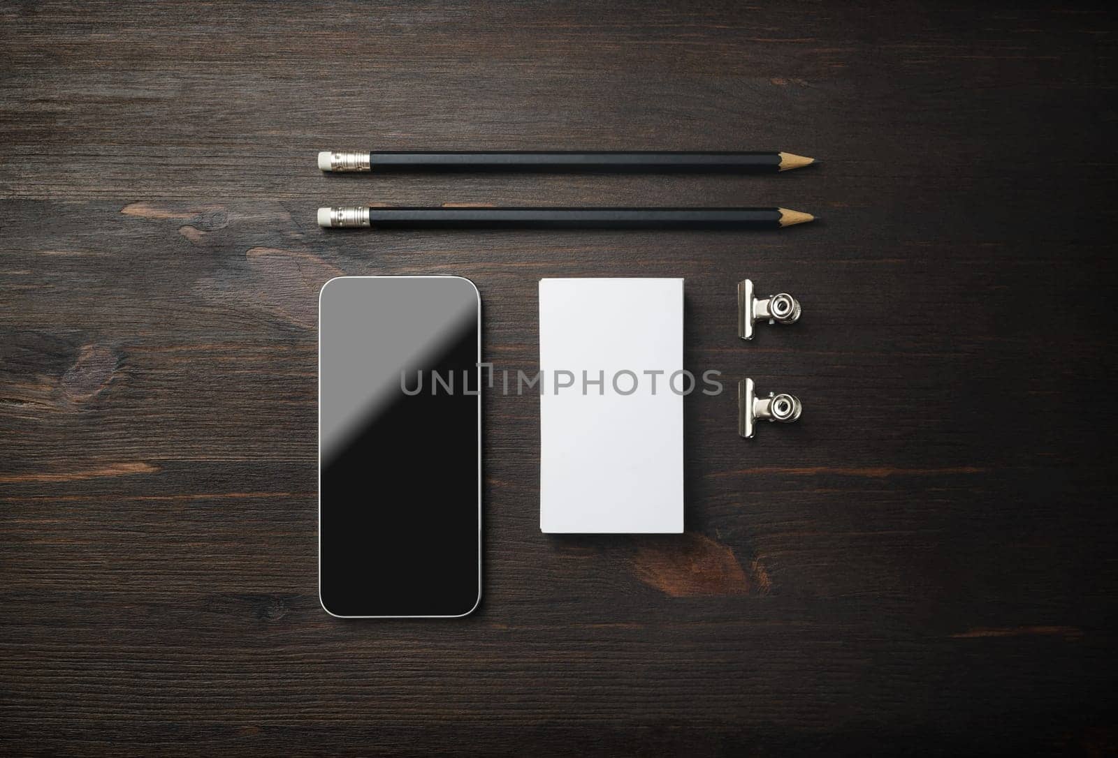 Smartphone, business card and pencils. Blank stationery set on wooden background. ID template. Mockup for branding identity for designers. Top view. Flat lay.