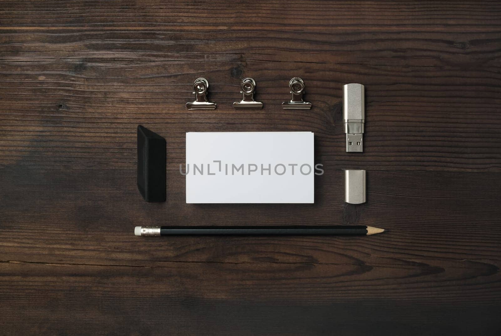 Blank stationery set. Blank business card, flash drive, pencil and eraser on wooden background. ID mockup. Responsive design template. Top view. Flat lay.