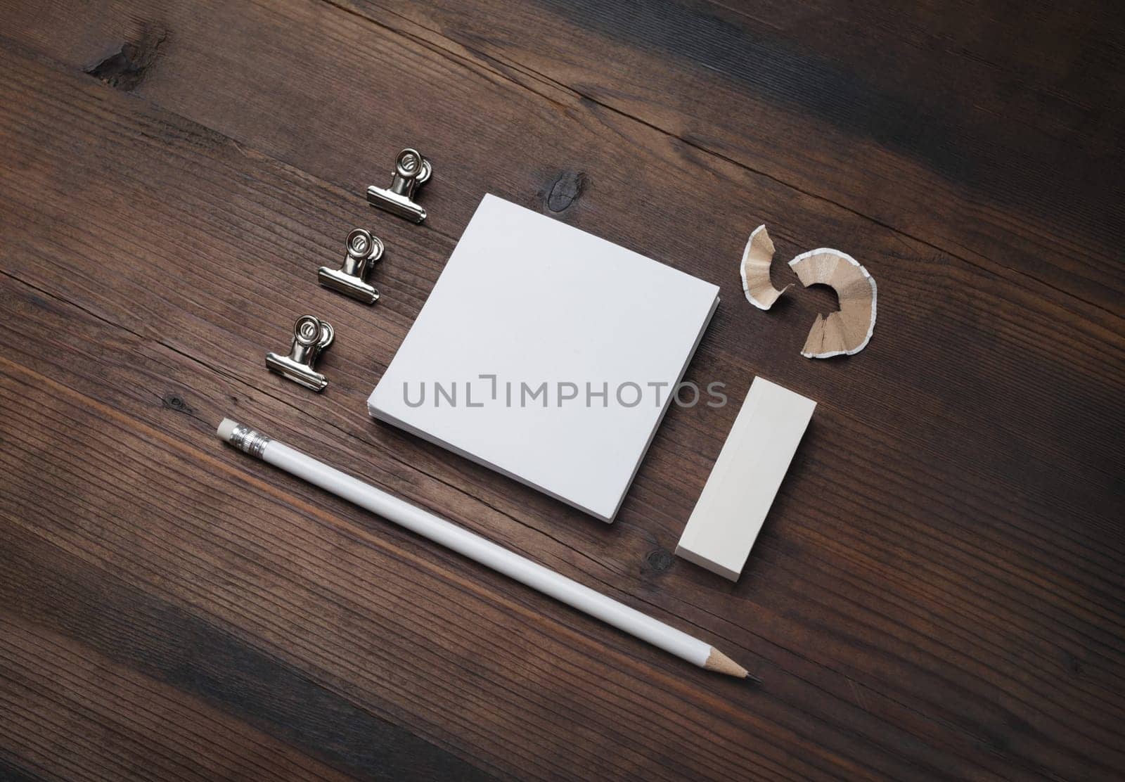 Photo of blank stationery set. Blank notes, pencil and eraser on wooden background.