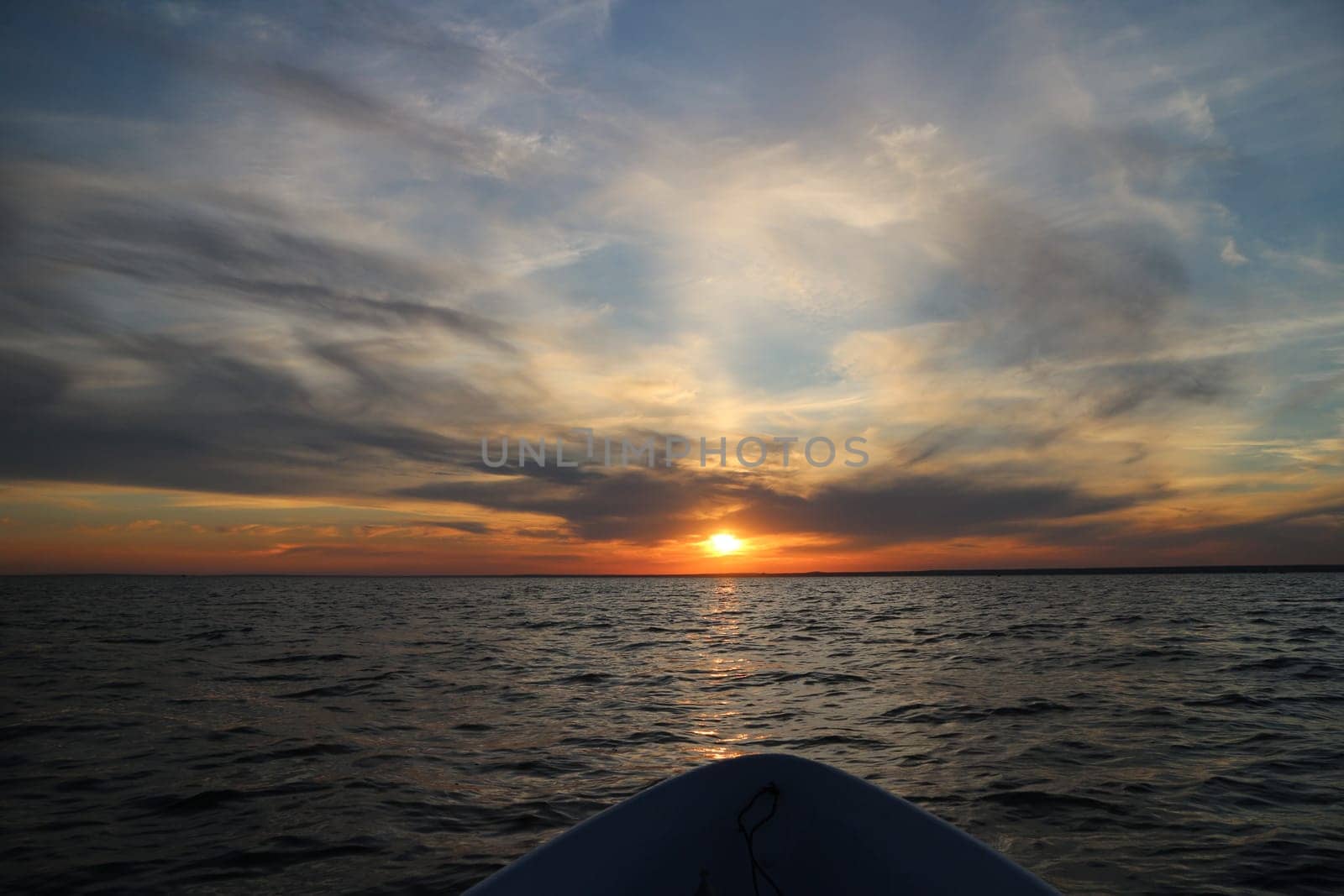 evening at sea setting sun on the course of the boat,  dramatic cloudy landscape