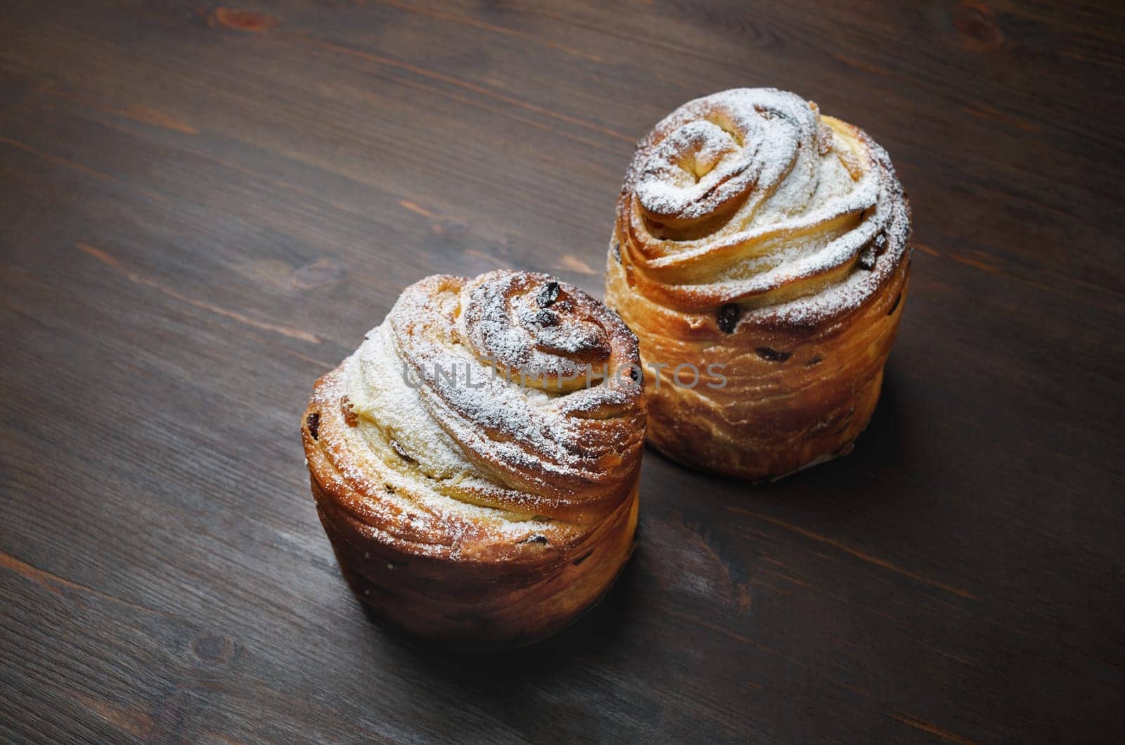 Two delicious sweet buns on wooden background