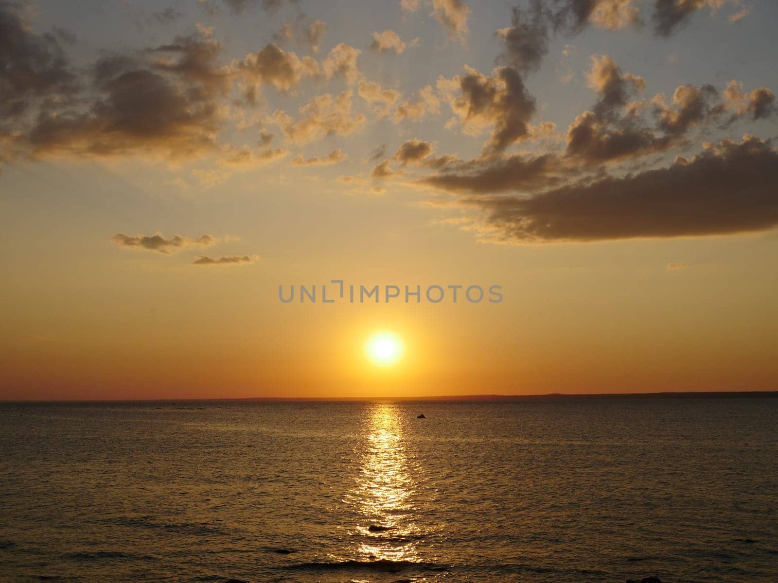 yellow sun sets over the sea and dusk falls