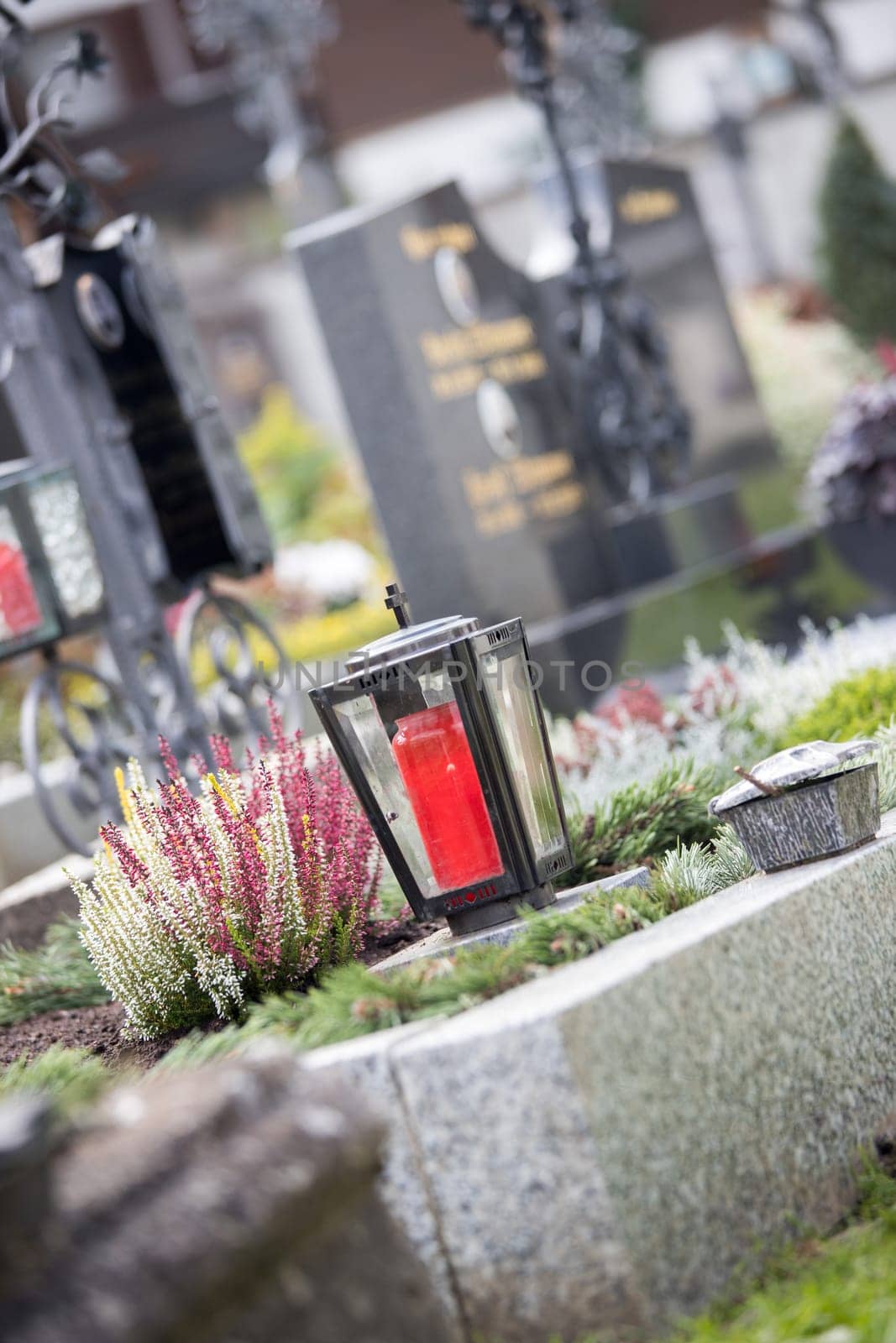 Candle in an iron lantern on a grave at a cemetery