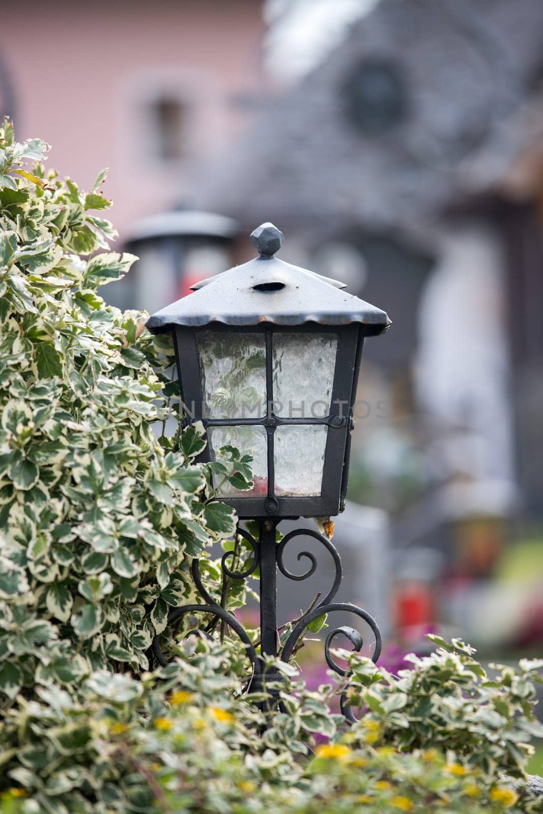 Candle in an iron lantern on a grave at a cemetery