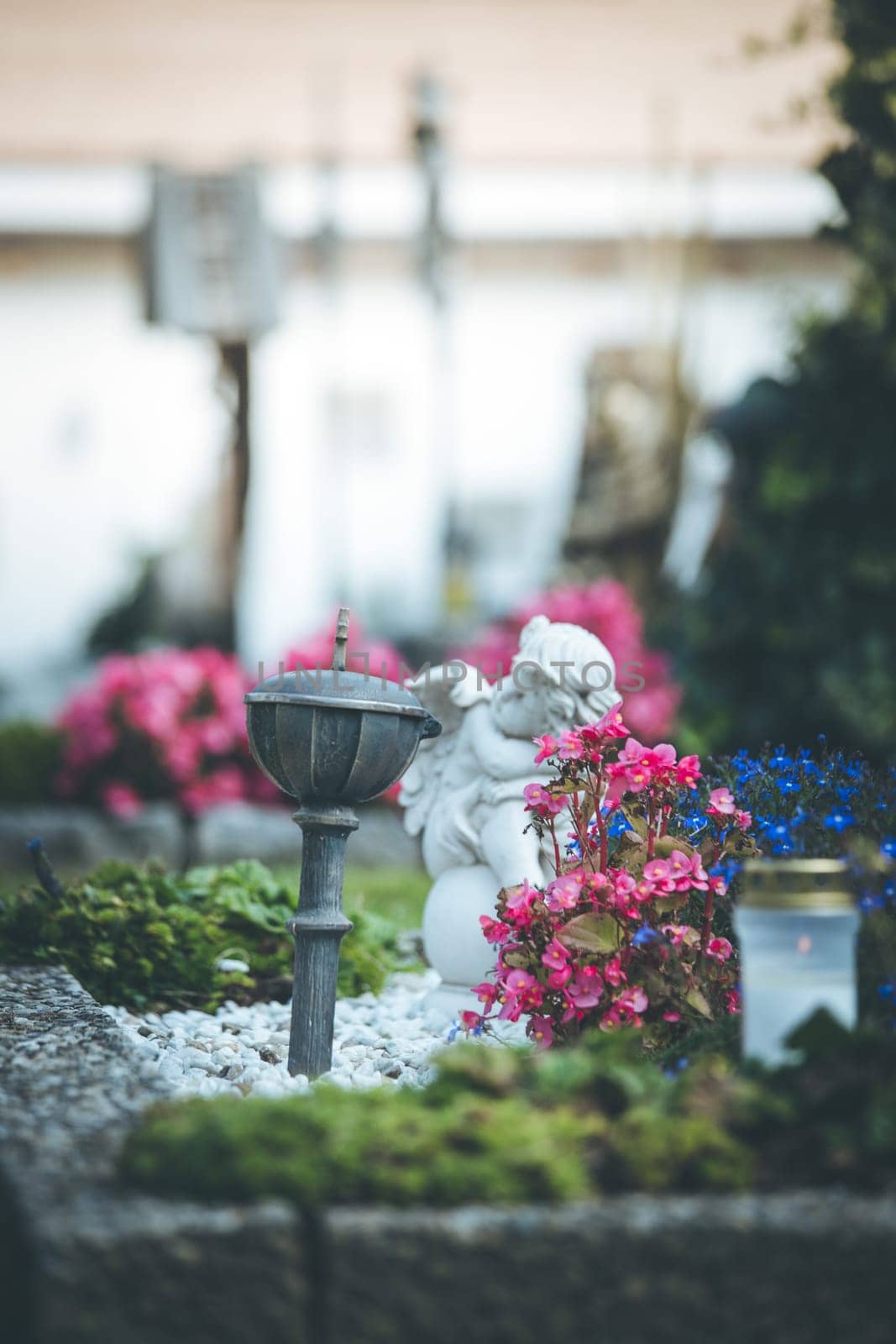 White angel on a grave at a cemetery, flowers