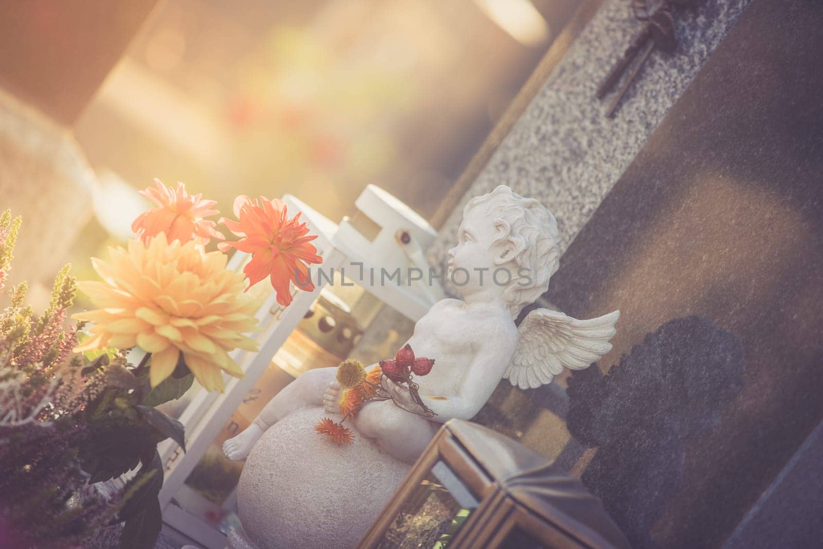 White angel on a grave at a cemetery, flowers