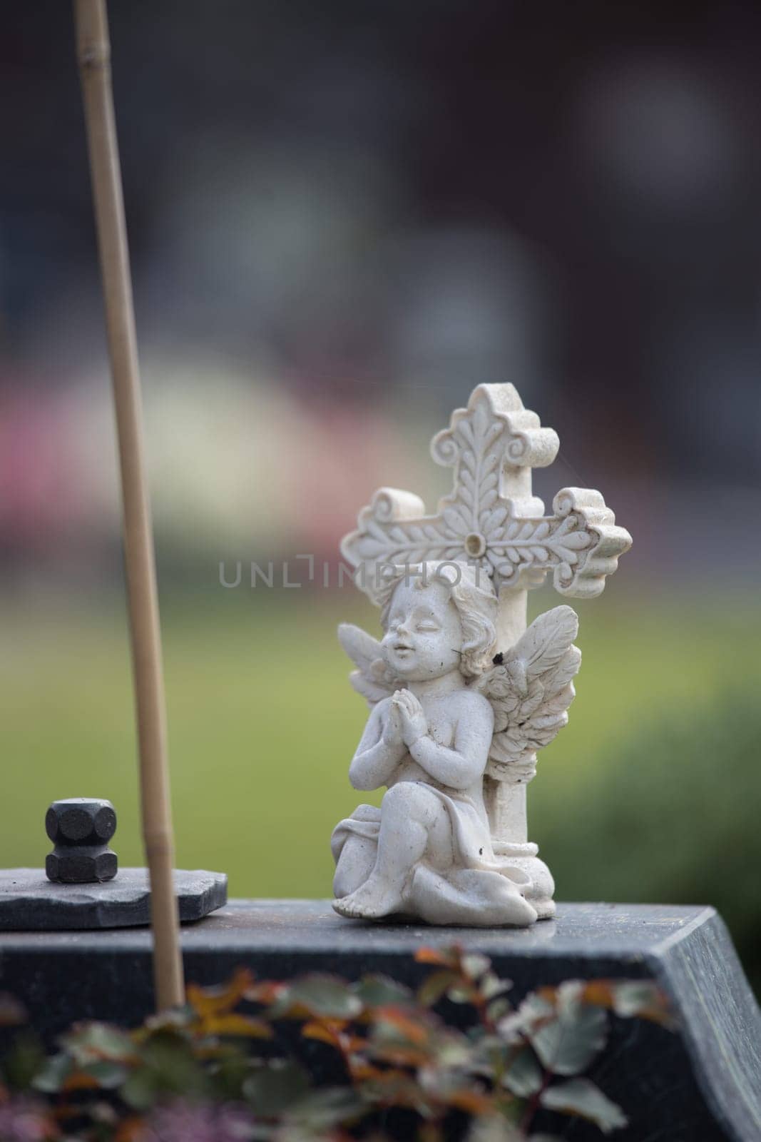 White angel on a grave at a cemetery, flowers