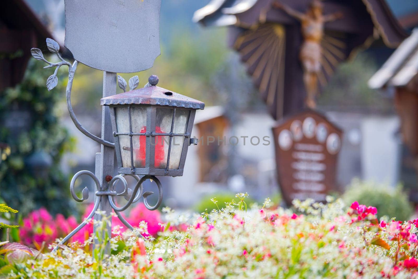 Candle in an iron lantern on a grave at a cemetery