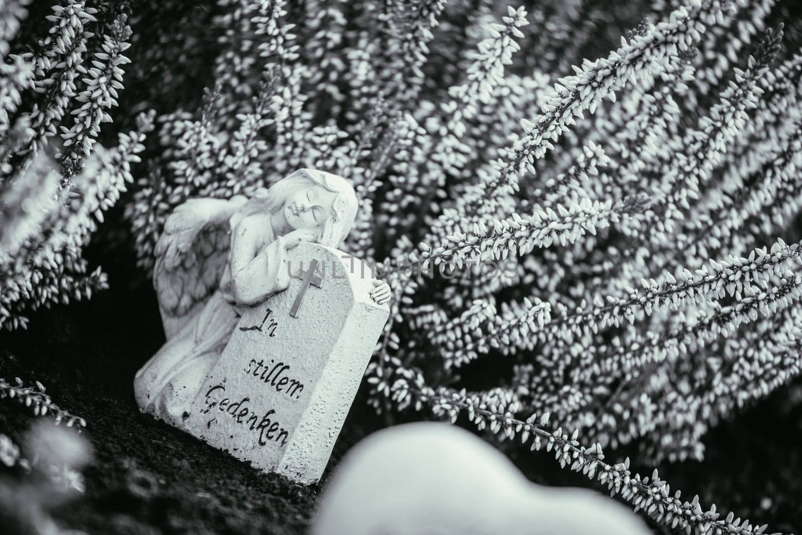 White angel on a grave at a cemetery, flowers
