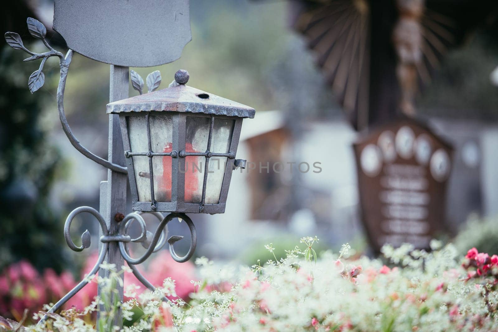 Candle in an iron lantern on a grave at a cemetery
