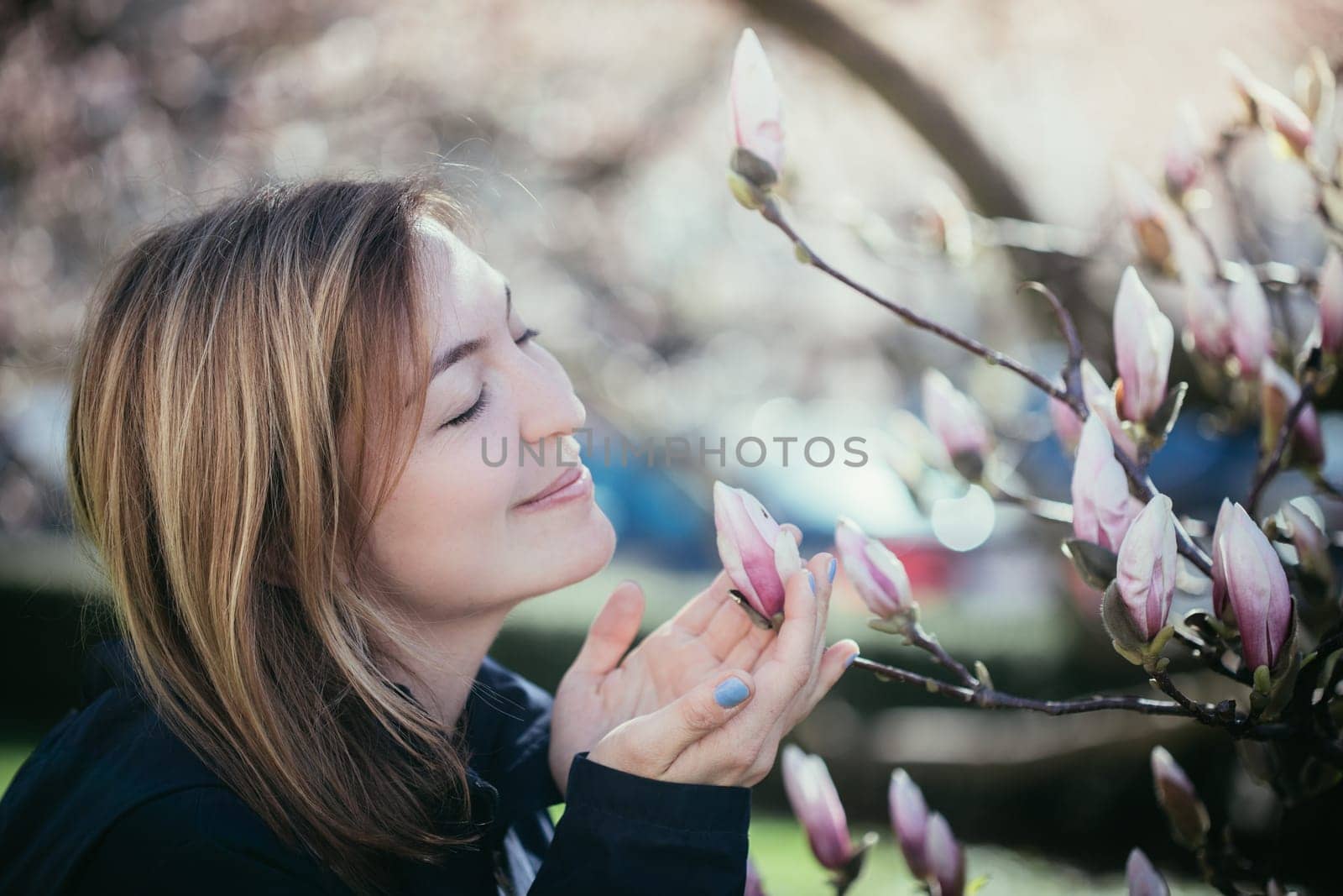 Beautiful girl is smelling magnolia blooms in spring, Salzburg, beauty