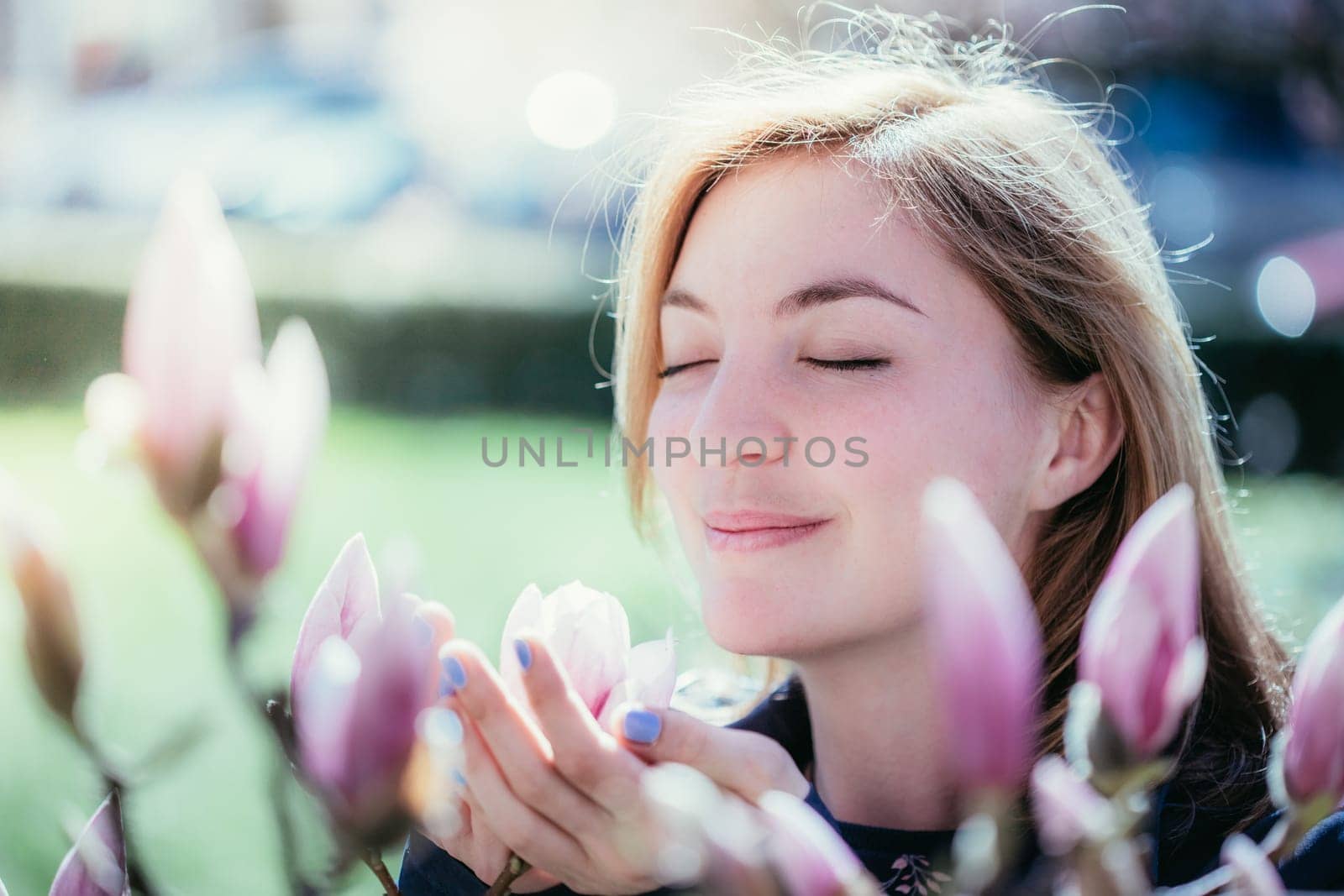 Beautiful girl is smelling magnolia blooms in spring, Salzburg, beauty