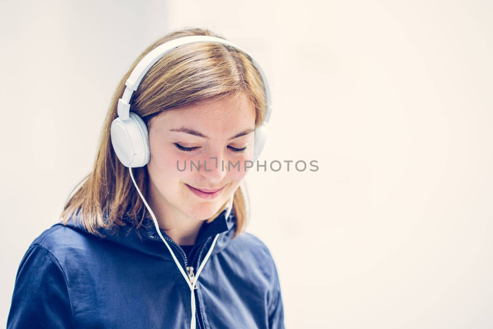 Young cute girl is listening to music with headphones