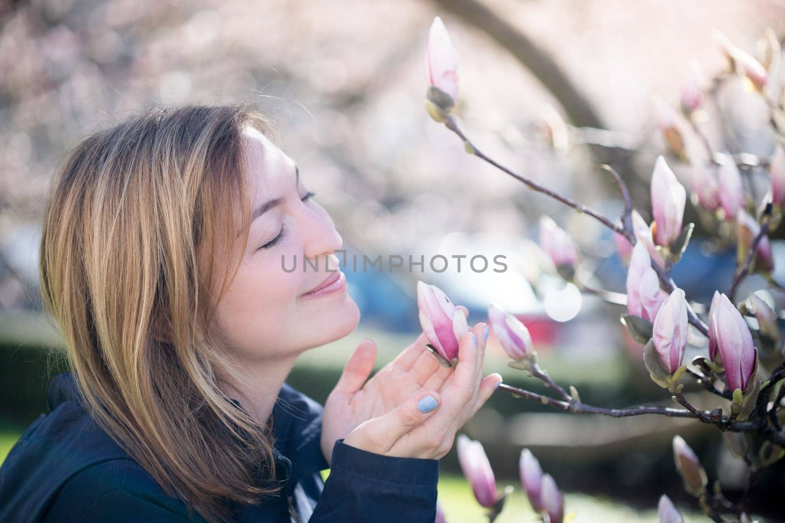 Beautiful girl is smelling magnolia blooms in spring, Salzburg, beauty