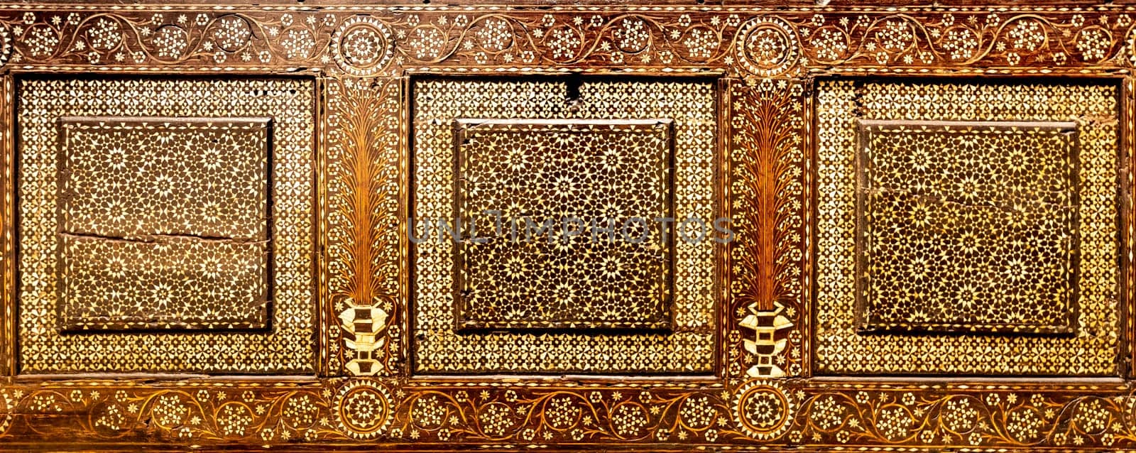 Antique art of wood decoration on a 15th century Italian furniture. Vintage and gothic background image.