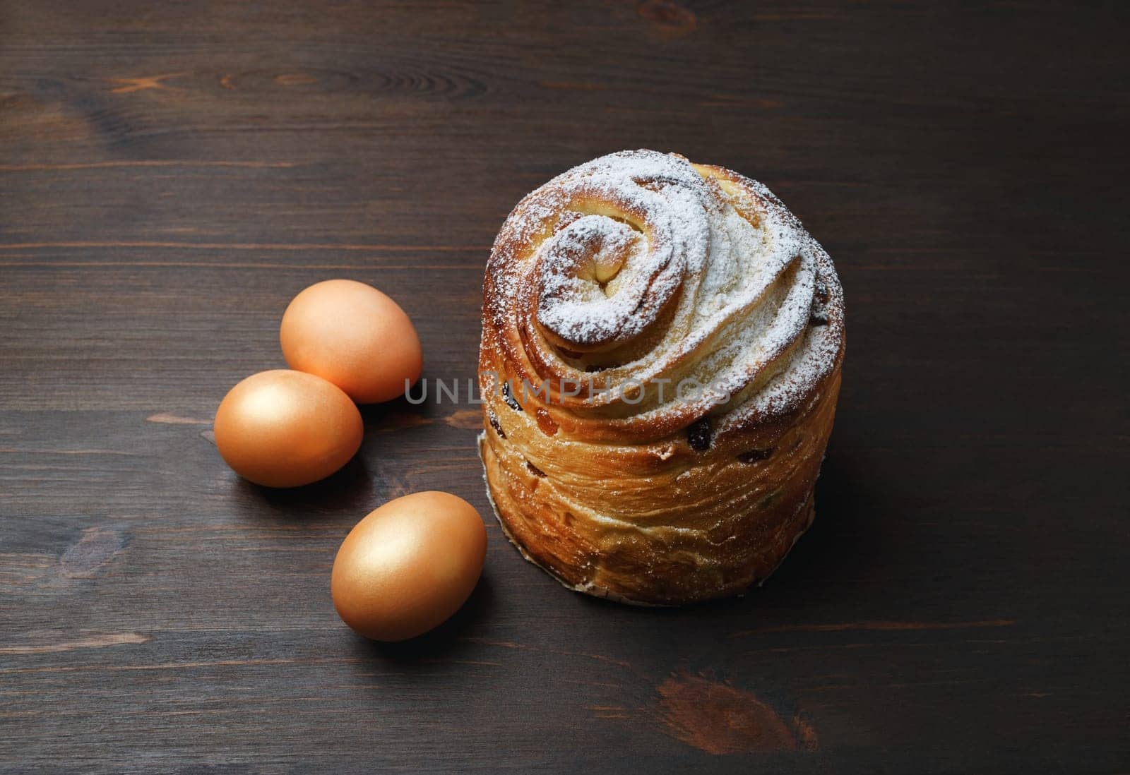 Delicious sweet bun and eggs on wooden background.
