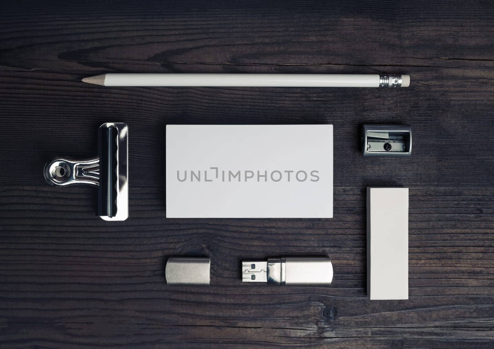 Blank stationery set on wooden background. Business card, pencil, eraser and flash drive. Top view. Flat lay.