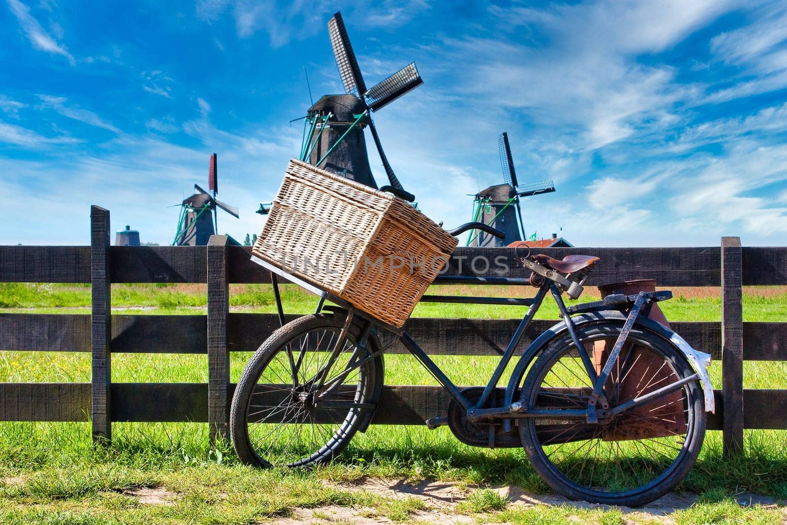 Bicycle with windmill and blue sky background. Scenic countryside landscape close to Amsterdam in Netherlands.