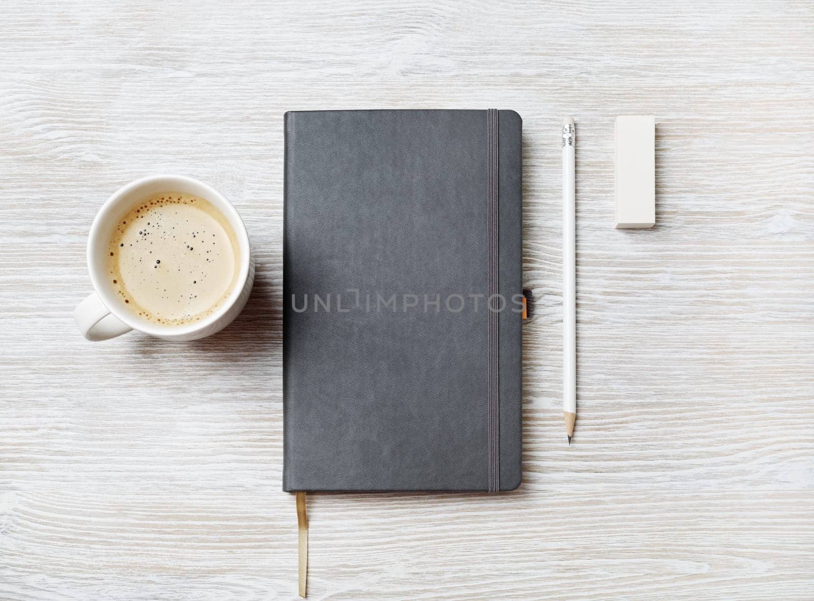 Blank notebook, pencil, eraser and coffee cup on light wooden background. Responsive design template. Top view. Flat lay.
