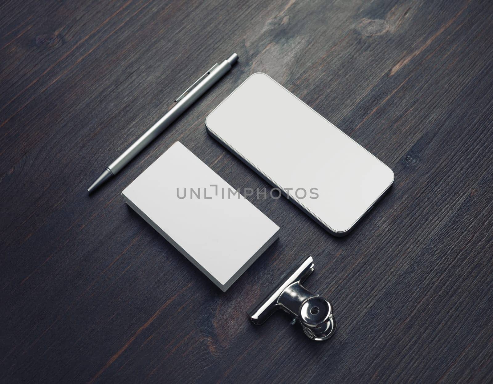 Blank business card, smartphone and pen on wood table background. Responsive design template.