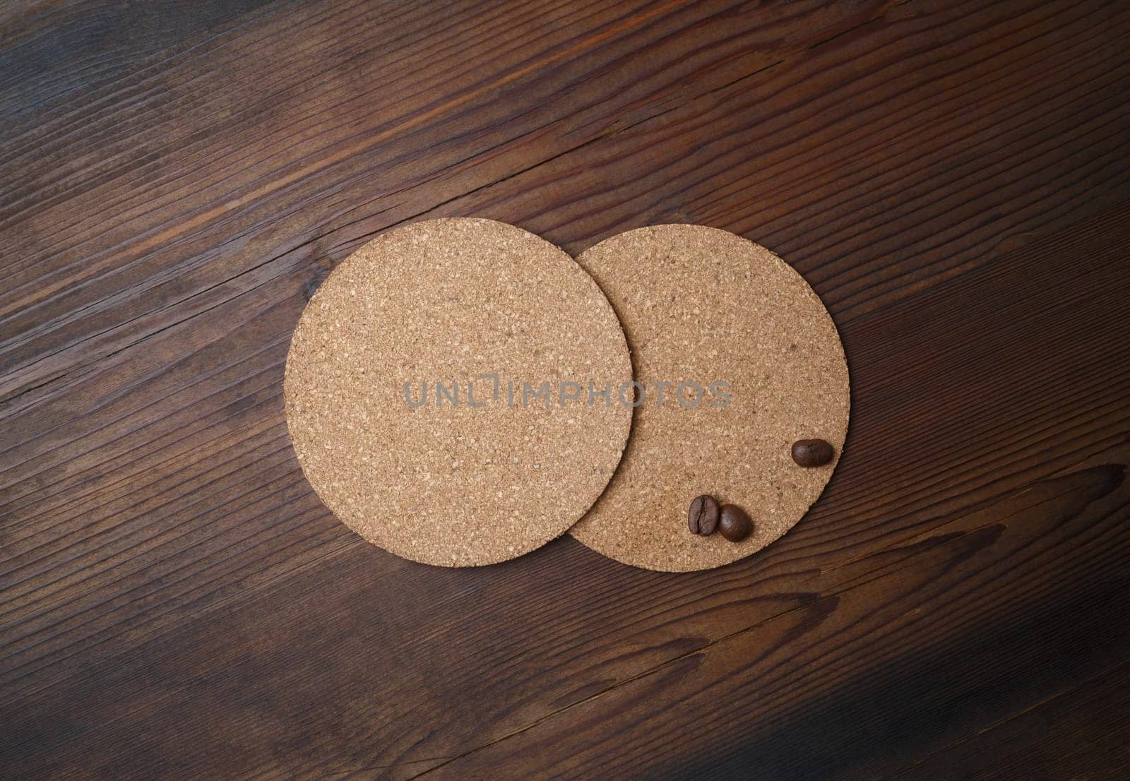 Blank beer coasters and coffee beans on wood table background. Top view. Flat lay.