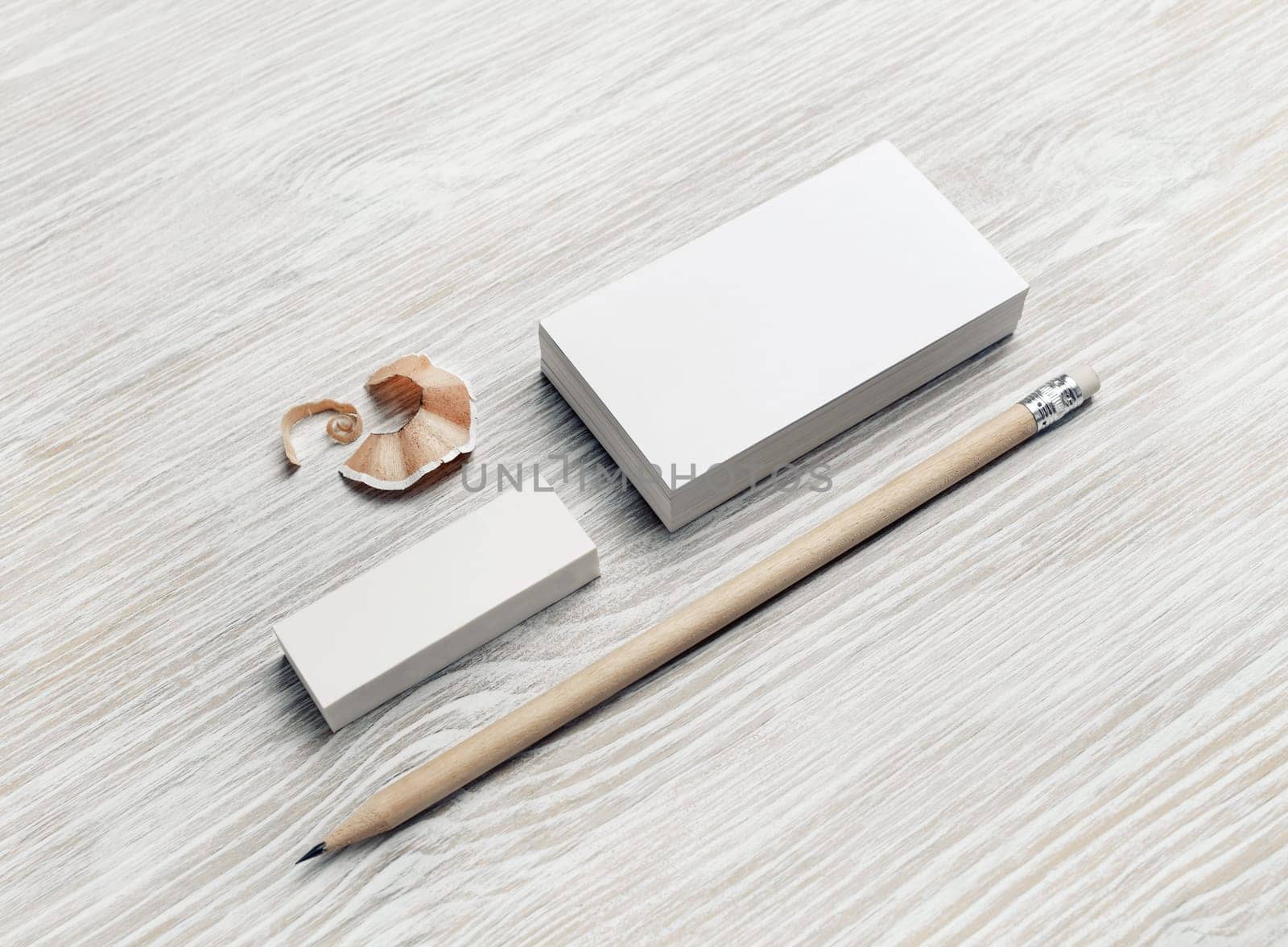 Blank stationery set. Blank business cards, pencil and eraser on light wooden background.