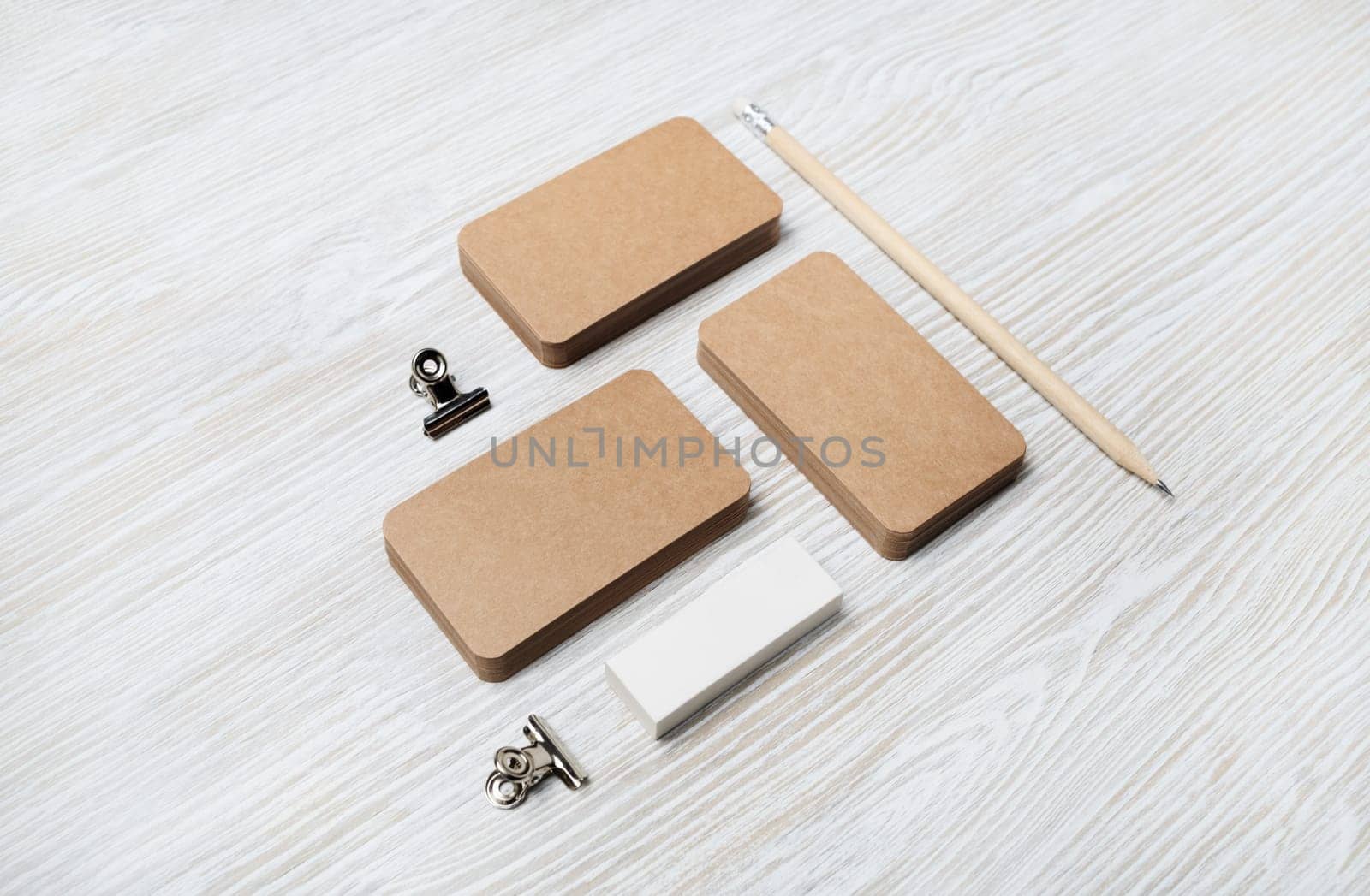 Blank vintage business cards, pencil and eraser on light wooden background. ID template. Mock-up for branding identity for designers.